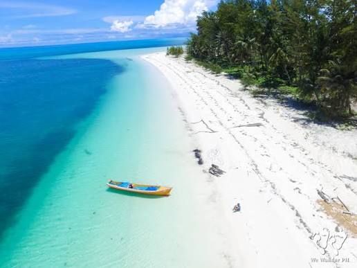 Vue aérienne de la plage blanche de Punta Sebaring avec une petite embarcation isolée