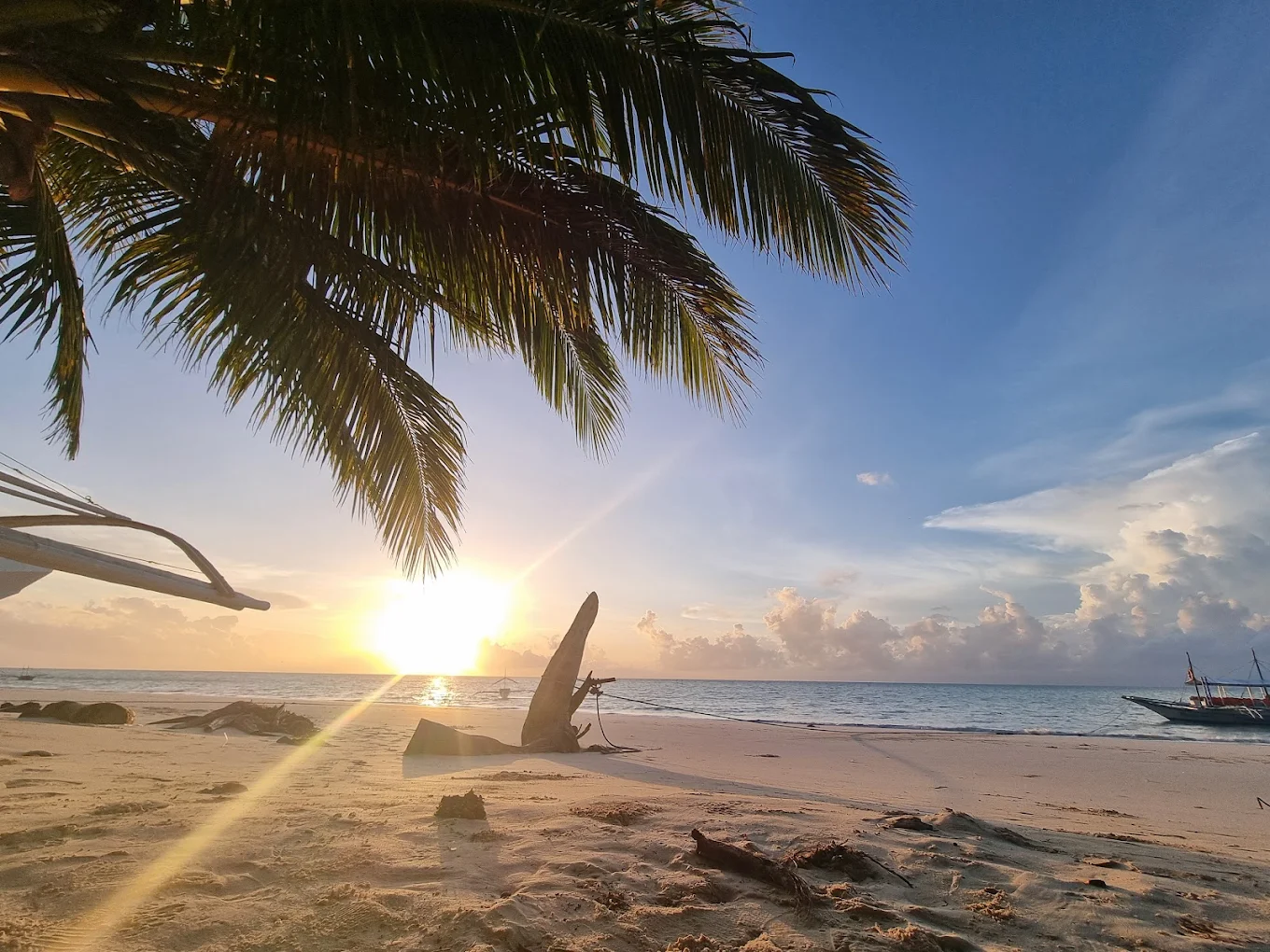 Coucher de soleil sur la plage de Punta Sebaring, palme et bangka en contre-jour