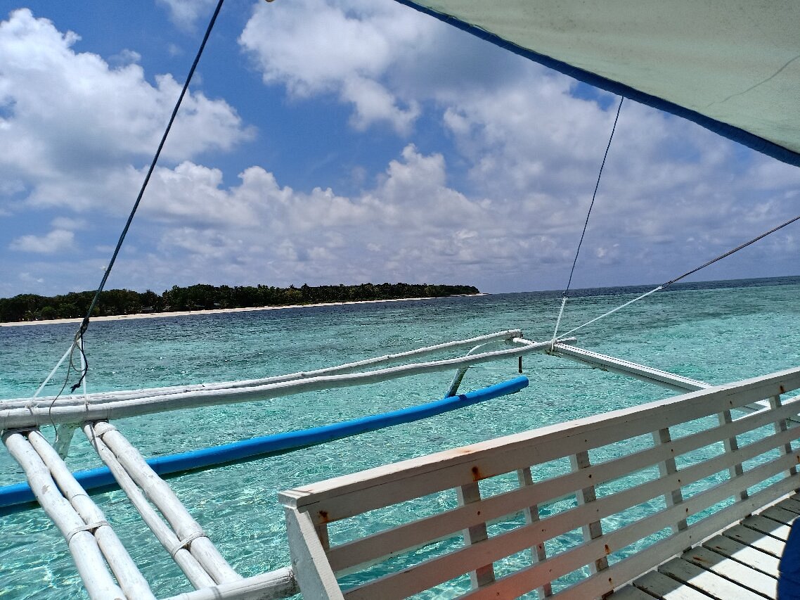 Vue depuis un bangka approchant l'île de Candaraman sur eau turquoise